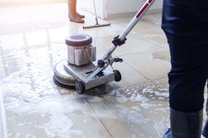 janitor-use-floor-scrubber-machine-on-the-floor-hallway-office-building-or-walkway-after-school-and-classroom-work-job-with-sun-light-background