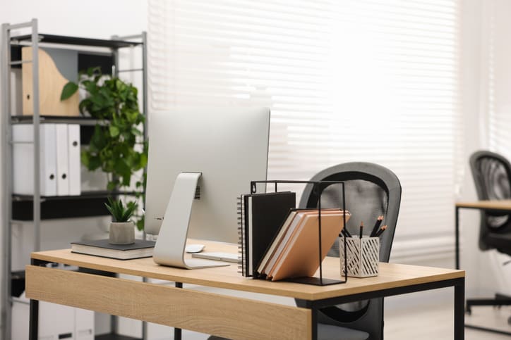 stylish-workplace-with-modern-computer-and-stationery-on-wooden-table-in-office